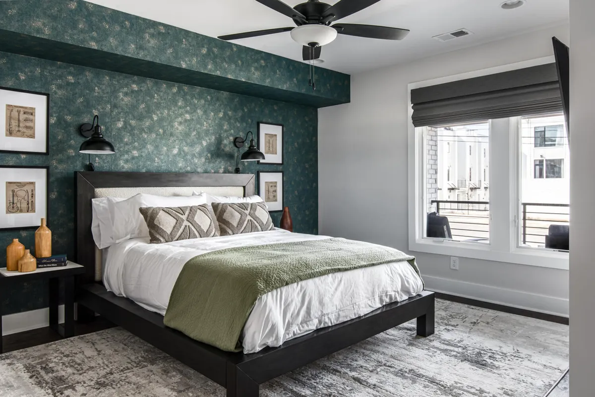 An inviting bedroom with a neatly made bed, tasteful wall art, a nightstand, and a window allowing natural light to filter in. The mood is restful and cozy, perfect for unwinding in private comfort.